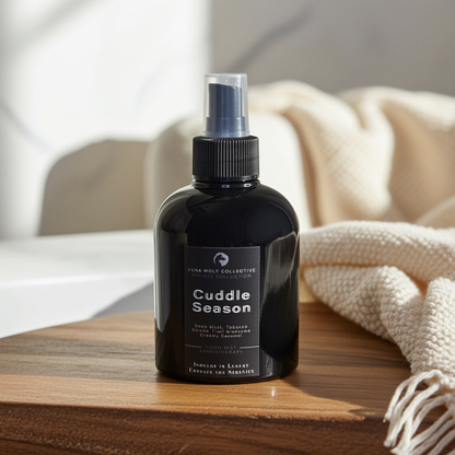 Black spray bottle labeled 'Cuddle Season' on a wooden surface with a blurred background